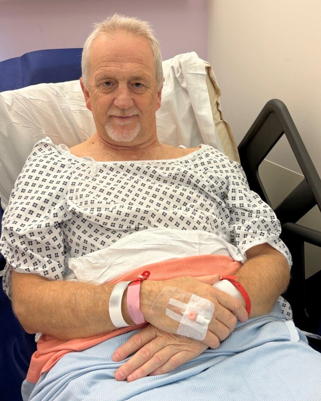 Nigel Howlett in bed wearing a hospital gown