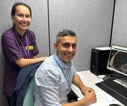 Clinical research practitioner Jess Camp and Dr Kuldeep Cheent sat by a computer