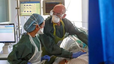 two nurses working around a coronavirus patient